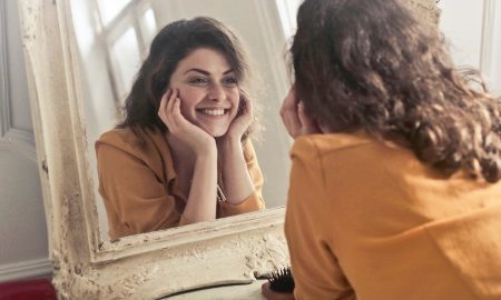 woman looking in the mirror smiling